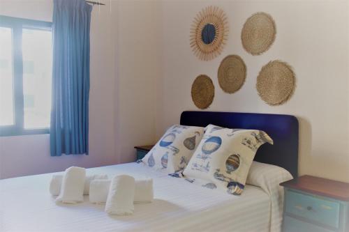 サアラ・デ・ロス・アトゥネスにあるAtlanterra Beach Apartmentのベッドルーム1室(青いヘッドボードと枕付きのベッド1台付)