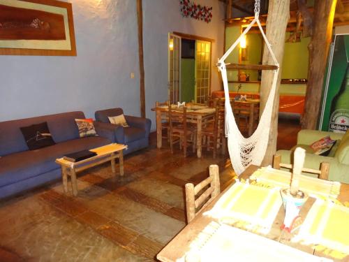 a living room with a couch and a hammock at Pousada Das Candeias in Carrancas
