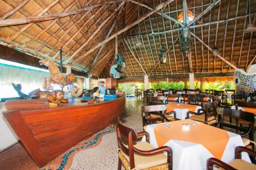 a restaurant with tables and chairs and a bar at Casa del Mar Cozumel Hotel & Dive Resort with free access to an exclusive beach club in Cozumel