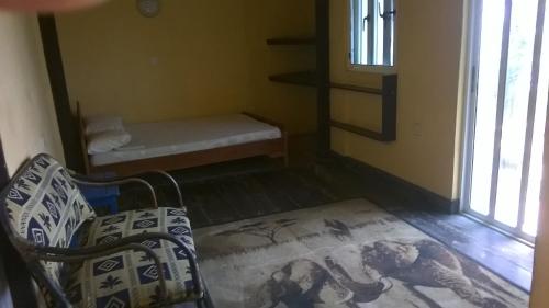 um quarto com uma cama e um banco num quarto em Rising Phoenix em Acra