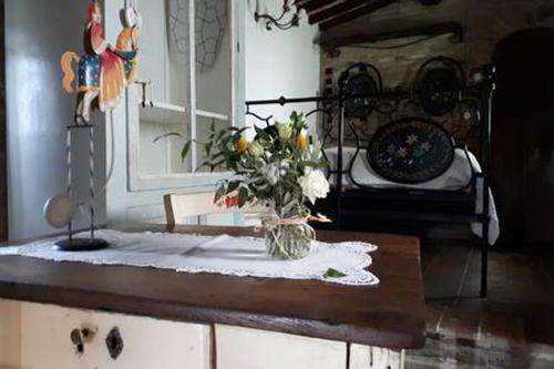 een vaas met bloemen op een tafel met een bed bij Podere Casina Rossa in Poppi