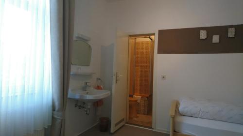 La salle de bains est pourvue d'un lavabo, d'un lit et d'un miroir. dans l'établissement Gasthof zur Post, à Cobbenrode