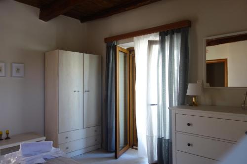 een slaapkamer met een bed, een dressoir en een raam bij Villa Eleni in Lithínai