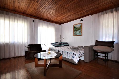 een slaapkamer met een bed, een tafel en een stoel bij Apartma Mika in Most na Soči