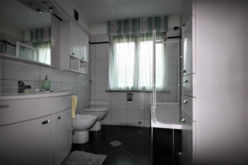 een witte badkamer met een toilet en een wastafel bij Apartma Mika in Most na Soči