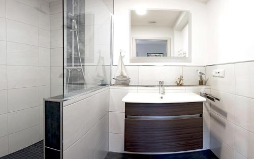 a white bathroom with a sink and a mirror at Haus Josef Klotten Wohnung 2 in Klotten