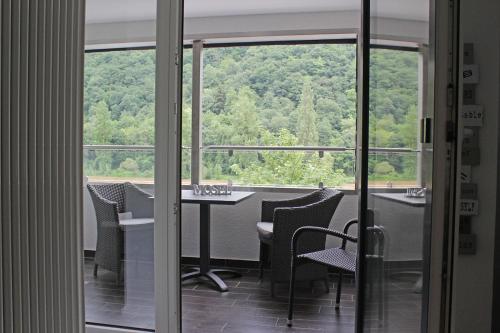 クロッテンにあるHaus Josef Klotten Wohnung 2のテーブルと椅子、窓が備わる客室です。
