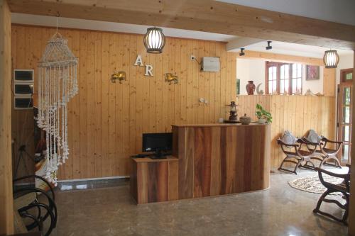 a room with wooden walls and a tv and chairs at Aloy's Residence in Digana