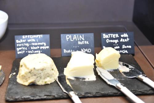 two pieces of cheese on a cutting board with spatulas at Solo Experience Hotel in Florence