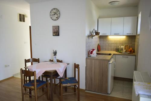a kitchen with a table and chairs in a room at Apartment Rina in Vantačići