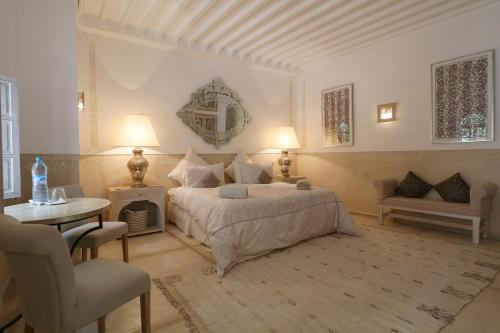 1 dormitorio con 1 cama, mesa y sillas en Medina Dream Riad Exclusive Rental, en Marrakech