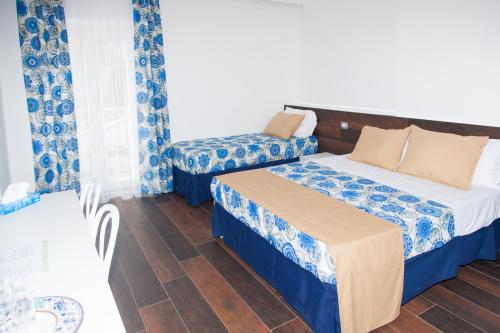 a room with two beds and a couch and a table at Casa Restino in Torre del Greco