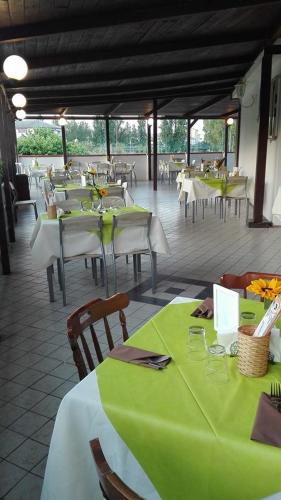 a restaurant with tables and chairs with green table cloth at Villaggio Costa d'Argento in San Vito Chietino