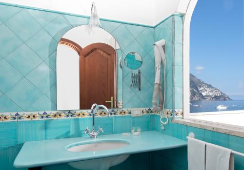 a bathroom with a sink and a mirror at Hotel Pupetto in Positano