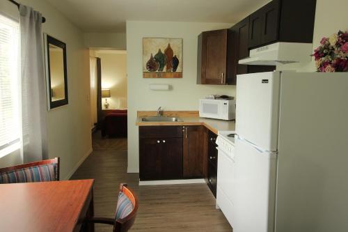a kitchen with a white refrigerator and a table at Mariners Cove Inn in Westport