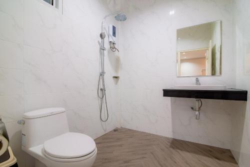 a white bathroom with a toilet and a sink at SEA Villa Hua Hin in Hua Hin
