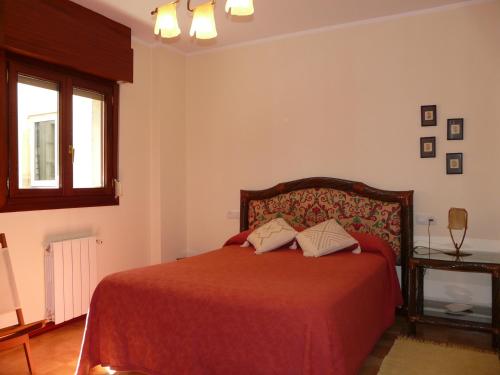 a bedroom with a red bed and a window at Sol 23 in Villaviciosa