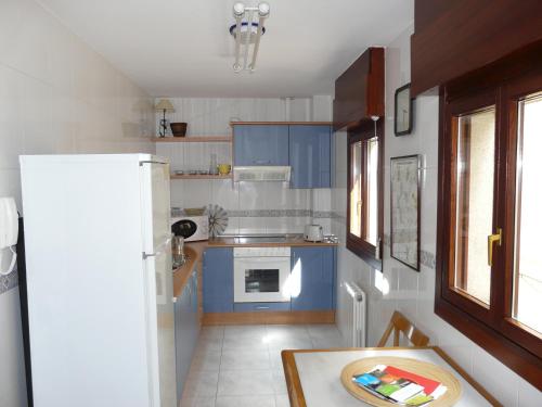 a kitchen with blue cabinets and a white refrigerator at Sol 23 in Villaviciosa