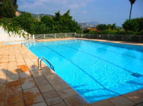 uma grande piscina com água azul em L'Agrianthe em Villefranche-sur-Mer