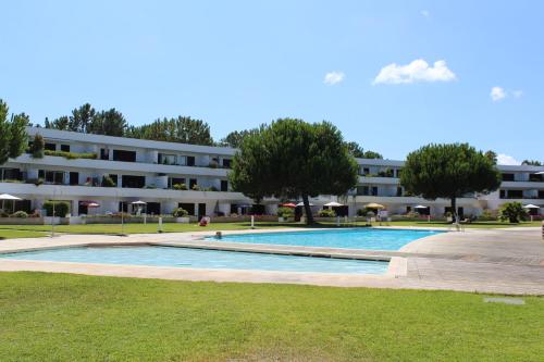 a swimming pool in front of a building at Refúgio Sol Tróia in Troia