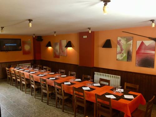 a dining room with long tables and chairs at Casa Francho in Laspaúles