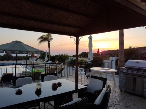 a patio with tables and chairs and a grill at Nayia Paradise Villa! Best Villa in Cyprus in Paphos City