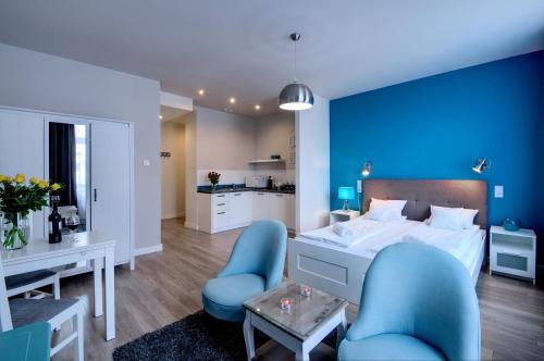 niebieska sypialnia z łóżkiem i 2 niebieskimi krzesłami w obiekcie Zamkowa15 Apartments w Krakowie