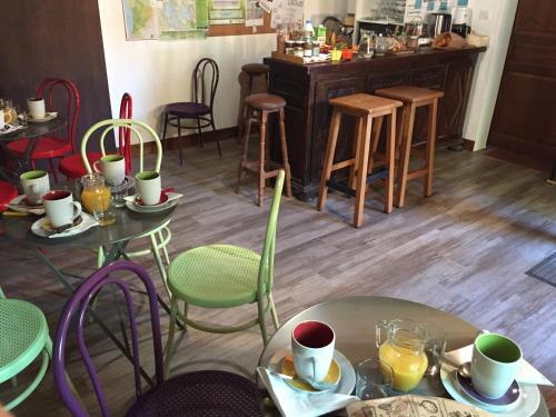 una habitación con mesas y sillas con tazas y platos en Cabane Escargot du centre UnisVers en Peyrat-le-Château