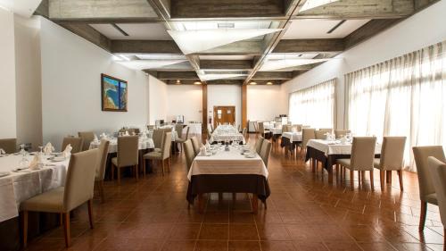 a dining room filled with tables and chairs at Hotel Santa Maria in Vila do Porto