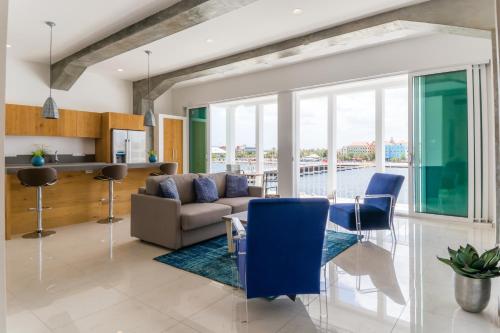 a living room with a couch and a table and chairs at Blue Marlin Handelskade Apartments in Willemstad