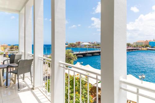 a balcony with a view of the water at Blue Marlin Handelskade Apartments in Willemstad