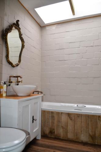 a bathroom with a sink and a toilet and a tub at The Stables Accommodation in Langebaan