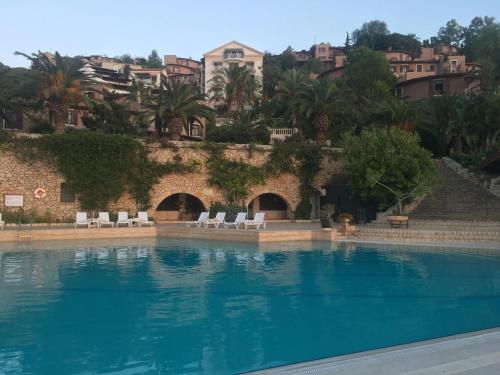 カルカンにあるClub Patara Villas 222の白い椅子と建物のある大きなスイミングプール