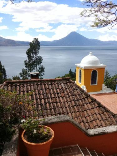 a building on the roof of a house next to the water at Hotel Casa Palopo in Santa Catarina Palopó