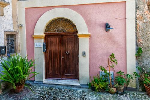 una porta di legno su un edificio rosa con una farfalla sopra di Alla Chiazzetta Calabria ad Amantea