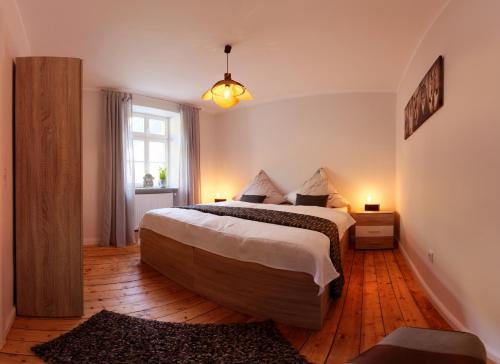 sypialnia z dużym łóżkiem i oknem w obiekcie Altes Lörscher Winzerhaus w mieście Mehring