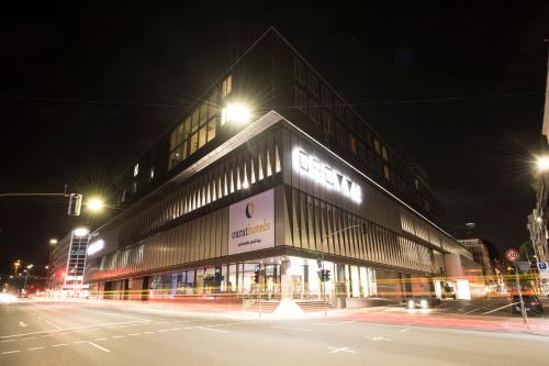 فندق كارات دوسلدورف سيتي في دوسلدورف: مبنى في شارع المدينة ليلا