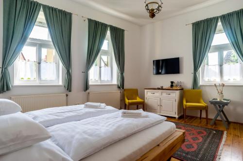 PalkonyaにあるVaj Bisztró és Vendégházのベッドルーム1室(ベッド2台、テレビ、窓付)