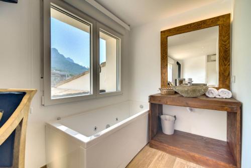 uma casa de banho com uma banheira, um lavatório e um espelho. em El Secret de la Forada Adult Only em Benissiva