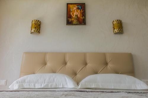 アドレルにあるApartment ot Marishyのベッド1台(枕2つ付)、壁に絵2枚