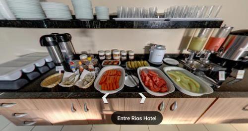 a kitchen counter with many plates of food on it at Entre Rios Hotel in Picos