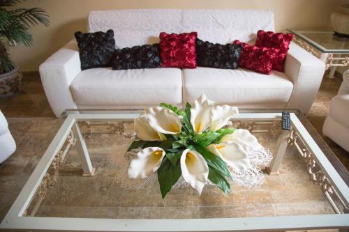 a living room with a white couch and flowers on a coffee table at Apartamento en Edificio Tortosa in Monóvar