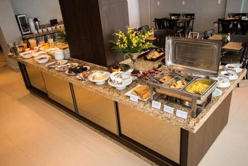 ein Frühstücksbuffet in einem Hotelzimmer mit Speisen in der Unterkunft Sense Hotel Premium in Capinzal