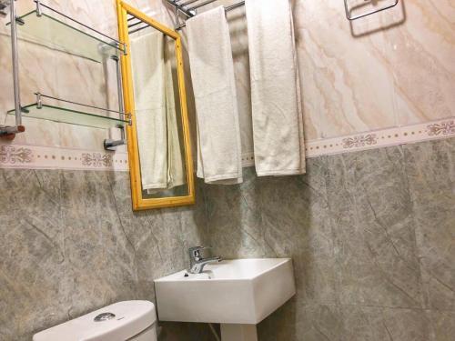 a bathroom with a sink and a toilet and a mirror at Mariana Maldives in Gaafaru