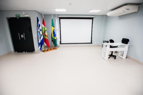 an empty room with flags and a door at Sense Hotel Premium in Capinzal