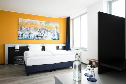 a living room with a bed and a tv at Carathotel Düsseldorf City in Düsseldorf