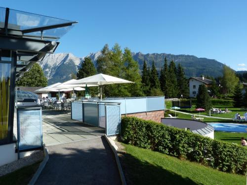 a resort with a pool and a table and umbrella at Hotel-Restaurant Grimmingblick in Bad Mitterndorf