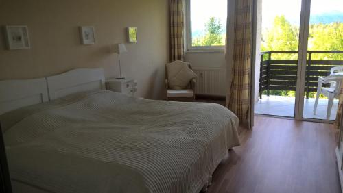 a bedroom with a bed and a sliding glass door at Ferienwohnung Mostecky in Ferlach