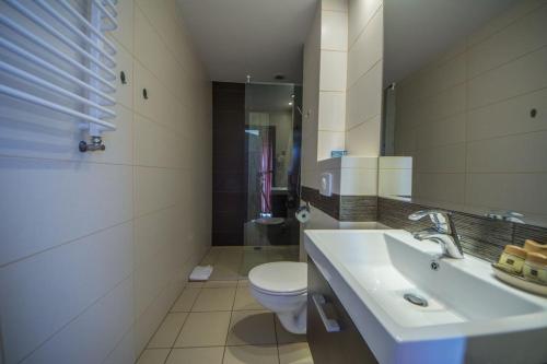 a bathroom with a white sink and a toilet at Villa Maritima in Grzybowo