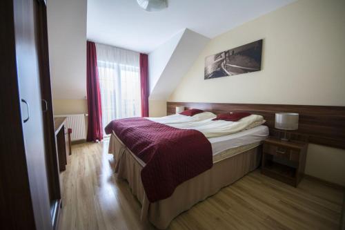a hotel room with a bed with a purple blanket at Villa Maritima in Grzybowo